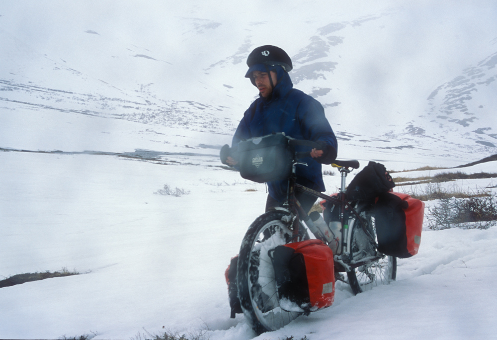 PUSHING THE BIKES UP TO THE PASS WAS MADE MORE DIFFICULT BY WET SNOW COLLECTING IN THE SPOKES.