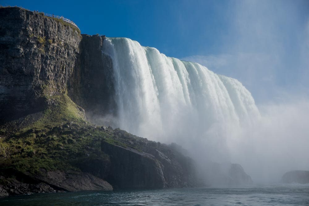 Massive waterfall crashing over a cliff edge, water droplets and spray frozen in sharp detail