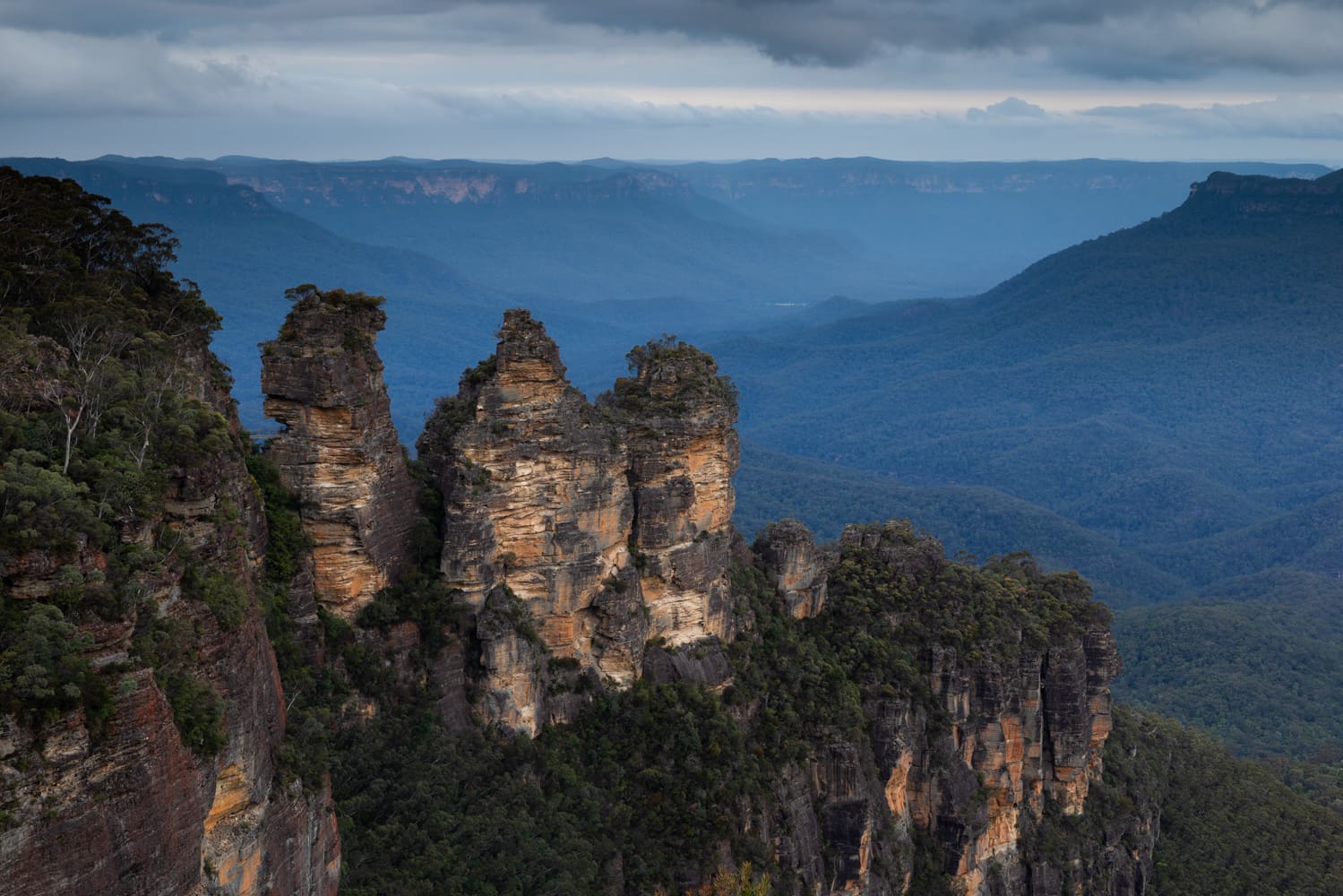 The Three Sisters rock formation at Echo Point above a deep blue valley in the Blue Mountains